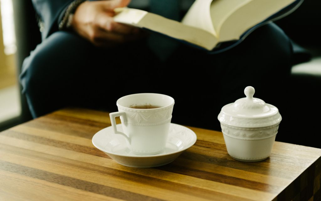 White sugar bowl and porcelain cup from KPM series Kurland stand on wooden table